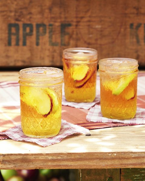 sparkling cider and bourbon cocktail in three mason jars with slices of fresh apple