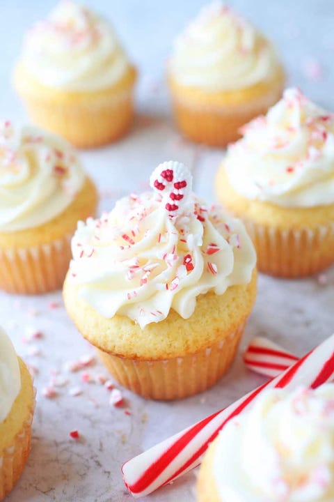 white cupcakes with peppermint buttercream frosting and candy canes