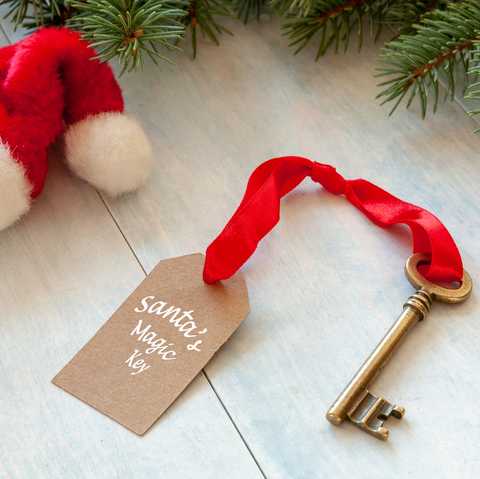 christmas activities santas magic key and santa hat close up on light blue wooden background