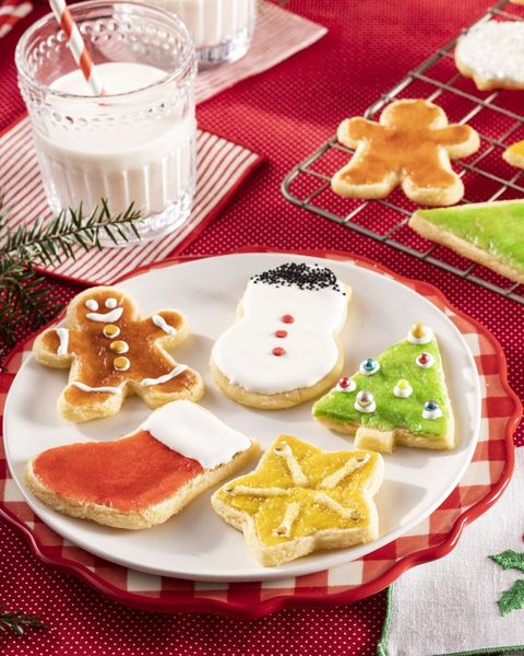christmas cookies on plate with glass of milk and red background