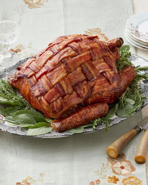 bacon wrapped turkey on bed of herbs