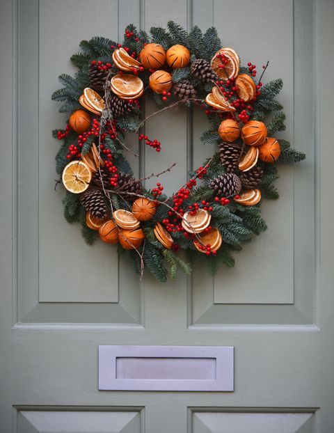 traditional decorative yule christmas wreath on a victorian front with period 19th century knocker and letter box door in london, uk