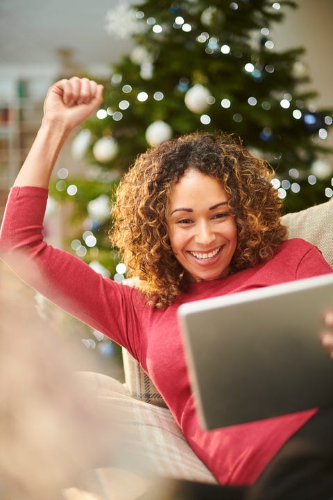 woman with an ipad and a christmas tree in the background