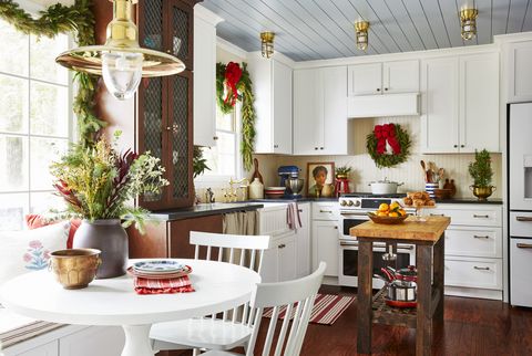 wreaths and garland hang in a mostly all white kitchen