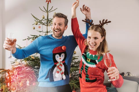 two adults in ugly christmas sweaters