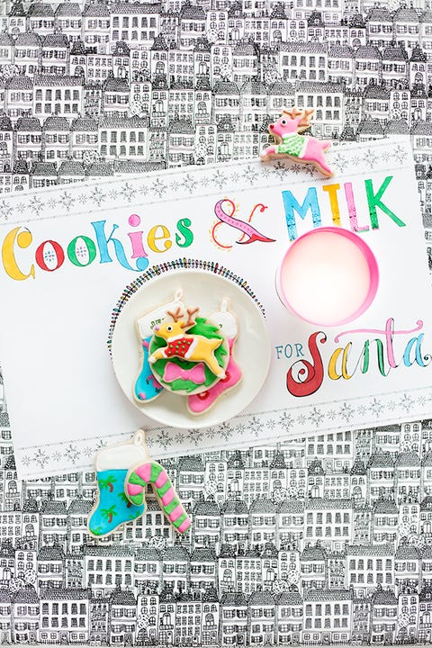 a paper placemat that says cookies and milk for santa and a plate of cookies and a glass of milk sit on top