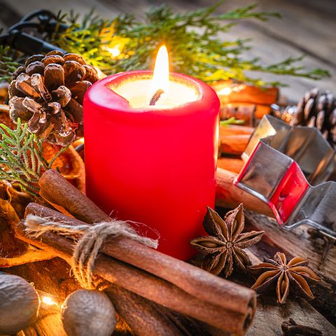 christmas backgrounds red burning christmas candle shot on rustic wooden table cinnamon sticks, star anise, cloves and nutmeg are around the candle the composition is at the left of an horizontal frame leaving useful copy space for text andor logo at the right predominant colors are red and brown high resolution 42mp studio digital capture taken with sony a7rii and sony fe 90mm f28 macro g oss lens