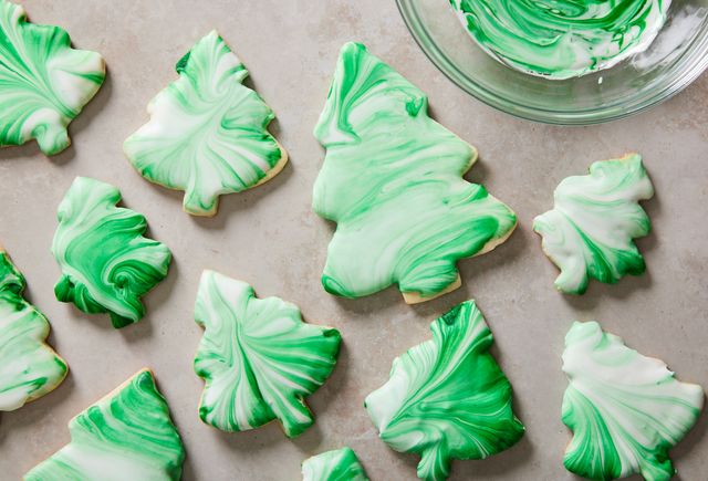 christmas tree cookies decorated with tie dye style green and white swirl icing