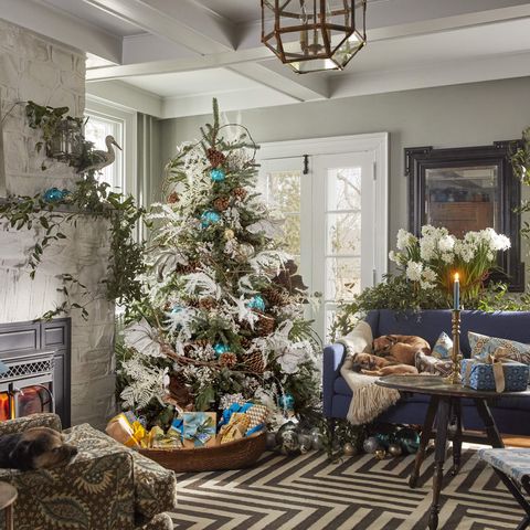 designer lewis miller's hudson valley home christmas tree with grapevine and smilax, cecropia leaves, and white statice stuffed in living room