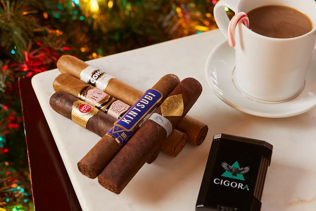 cigars on a table next to a cup hot chocolate