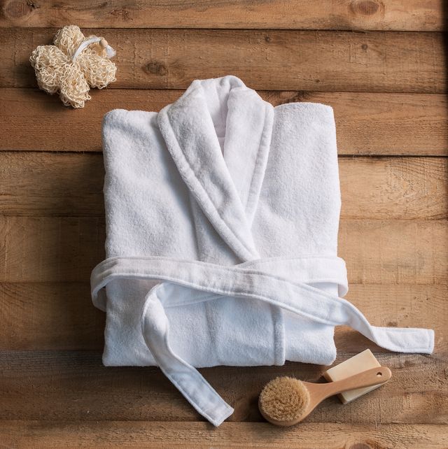 clean bathrobe with spa supplies on wooden background
