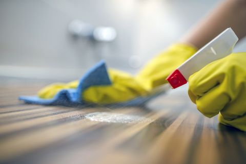 Cleaning kitchen table with blue cloth