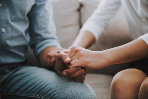 Close up. Man and woman hold hands tightly.