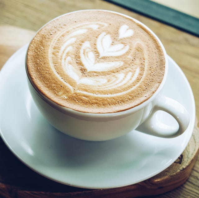 Close-up of a cup of hot latte coffee on the wooden table. Close-up of a cup of hot latte coffee on the wooden table.
