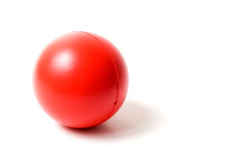 Close-up of a red rubber stress ball on white background