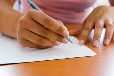 close up of adult hands writing with pen and paper