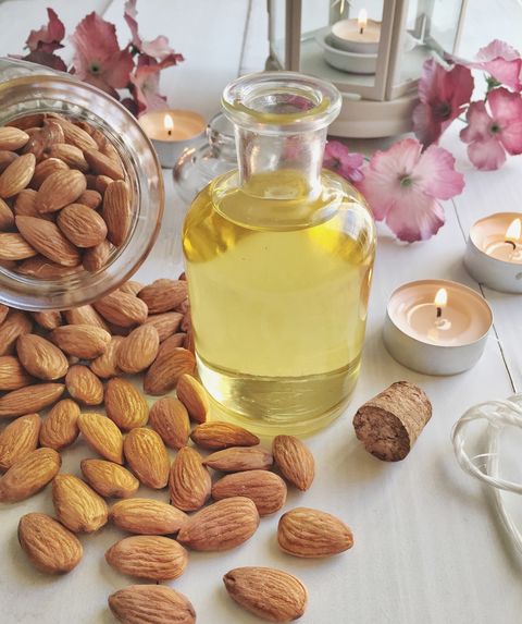 Close-Up Of Almonds And Oil In Bottle On Table