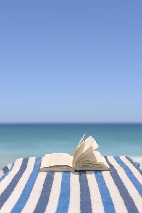 close up of book on deck chair on beach