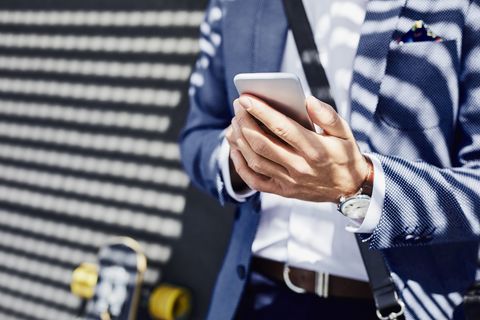 Close-up of businessman holding phone outdoors
