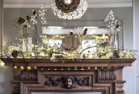 close up of christmas decorations on beautifully carved wooden mantelpiece, mirror above