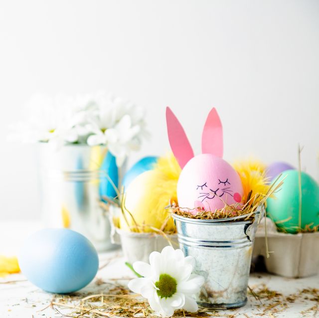 close up of colorful easter eggs on table against white background