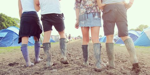 Close up of friends walking through a muddy campground