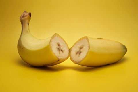 Close-Up Of Halved Bananas On Yellow Background
