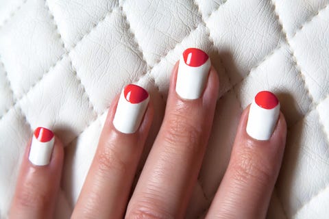 a manicure, featuring a white base color with a red flipped french manicure on a white textured background