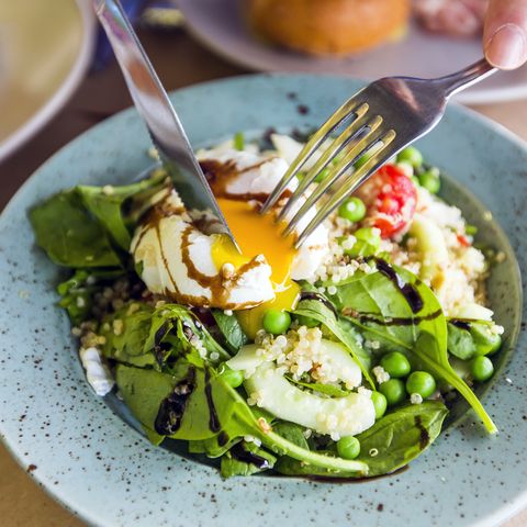 close up of healthy salad with quinoa, green peas, spinach and poached egg