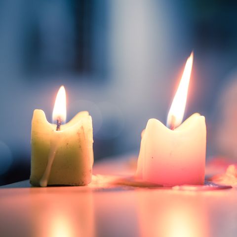 Close-Up Of Lit Candles On Table