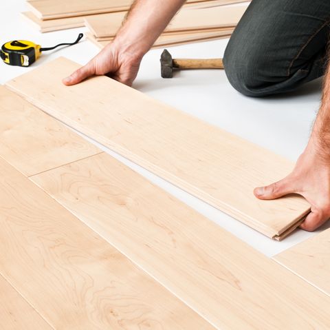 close up of man putting hardwood floor panels floorboards