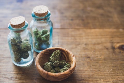 Close-Up Of Marijuana In Jar On Table Close-Up Of Marijuana In Jar On Table