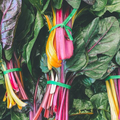 close up of multi colored leafy greens for sale in market