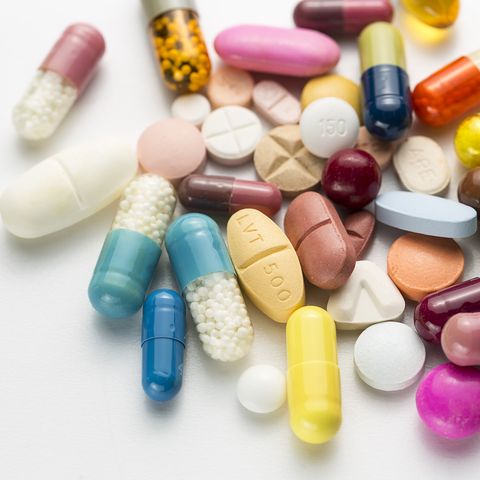 Close-Up Of Multi Colored Pills Over White Background