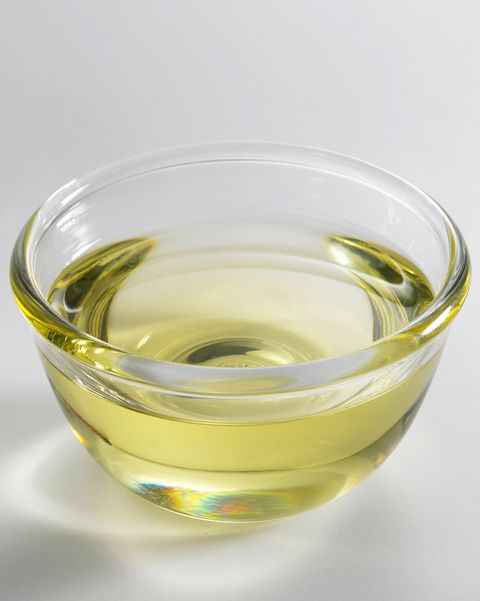Close-Up Of Oil In Glass Bowl Against White Background