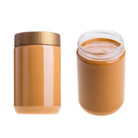 Close-Up Of Peanut Butter Jars Against White Background