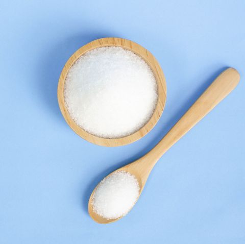 Close-Up Of Salt In Bowl And Spoon Against Blue Background