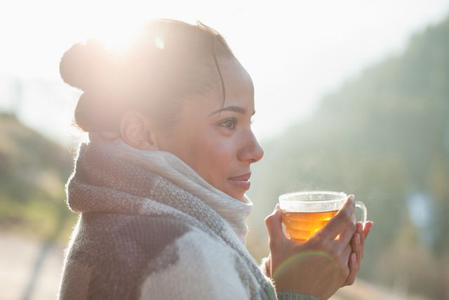 close up of smiling woman drinking tea outdoors
