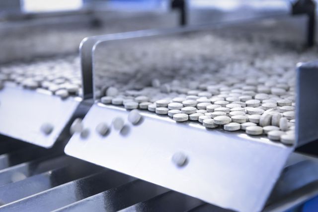 close up of tablets in packing machine in pharmaceutical factory