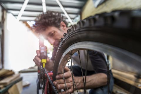 un mecánico lubricando la cadena de una bicicleta