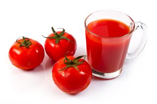Close-Up Of Tomatoes With Juice On White Background