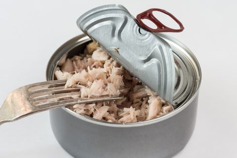 Close-Up Of Tuna In Container Against White Background