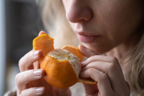 close up of woman eating orange