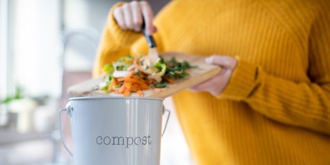 close up of woman making compost from vegetable leftovers in kitchen