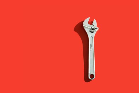 Close-Up Of Wrench On Red Background