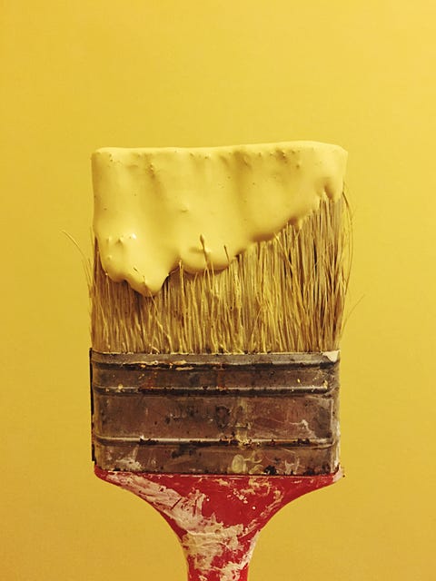 Close-Up Of Yellow Paint On Brush Against Wall