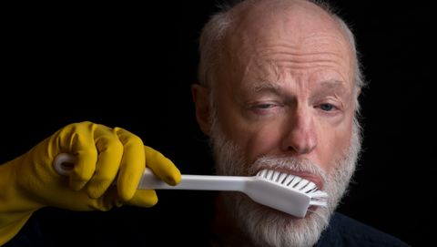 man poetst zijn tanden met een afwasborstel