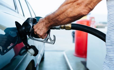 از نزدیک با دست های مرد سالخورده در حال سوخت گیری خودروی خود در پمپ بنزین مفهوم افزایش قیمت نفت