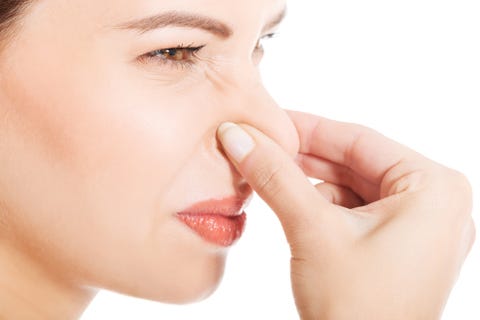 Close-Up Side View Of Mid Adult Woman Holding Nose Against White Background Close-Up Side View Of Mid Adult Woman Holding Nose Against White Background