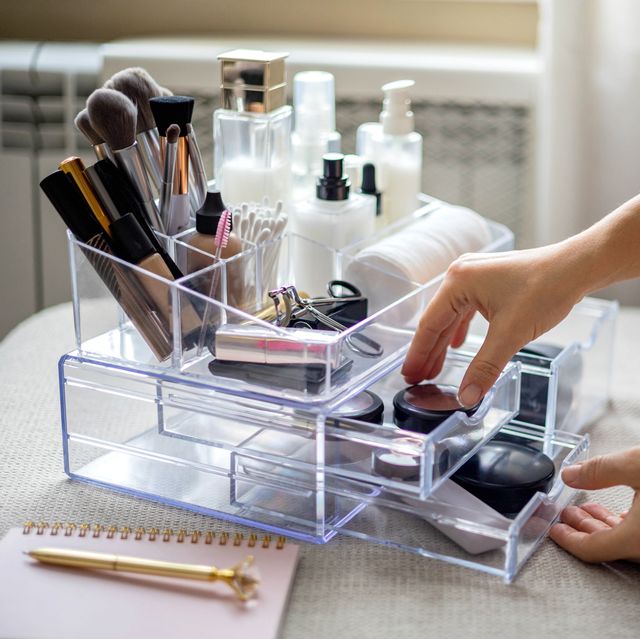 closeup female hands putting luxury cosmetic into acrylic box with drawer storage organization